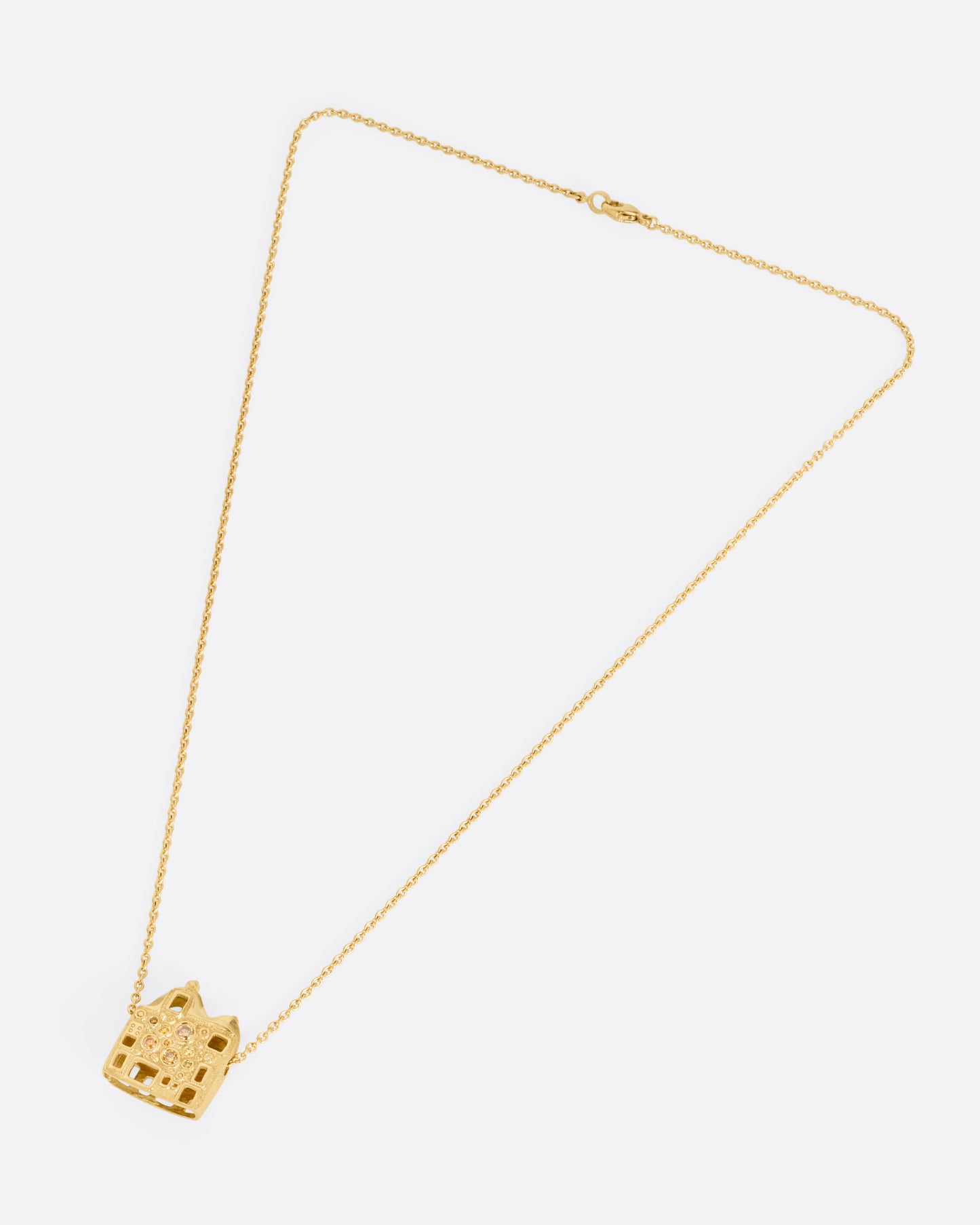 A yellow gold cable chain with a house shaped pendant with open windows and multicolored diamonds, shown from the front.