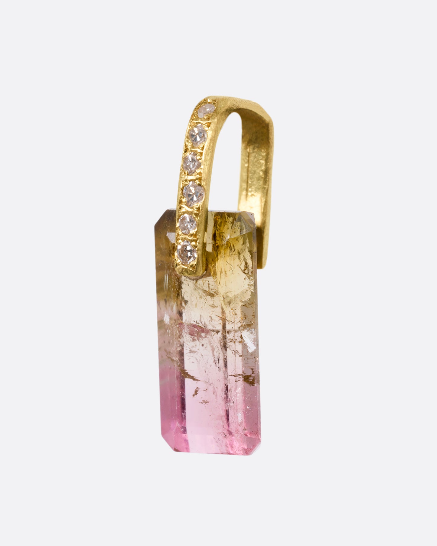 An emerald cut bicolor tourmaline charm with a yellow gold diamond lined bail. Shown from the side.