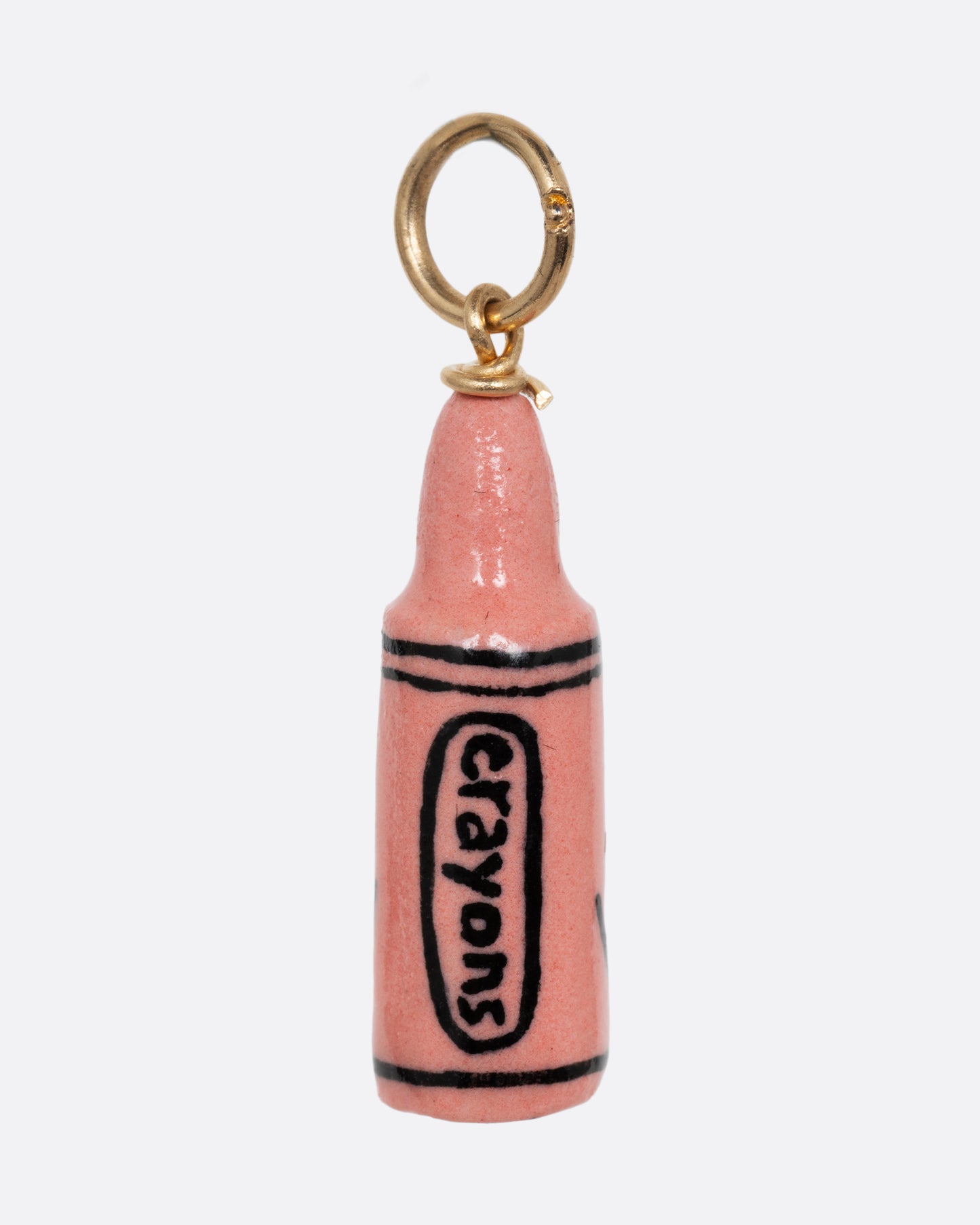 A pink crayon porcelain charm with a yellow gold bail. Shown from the back.