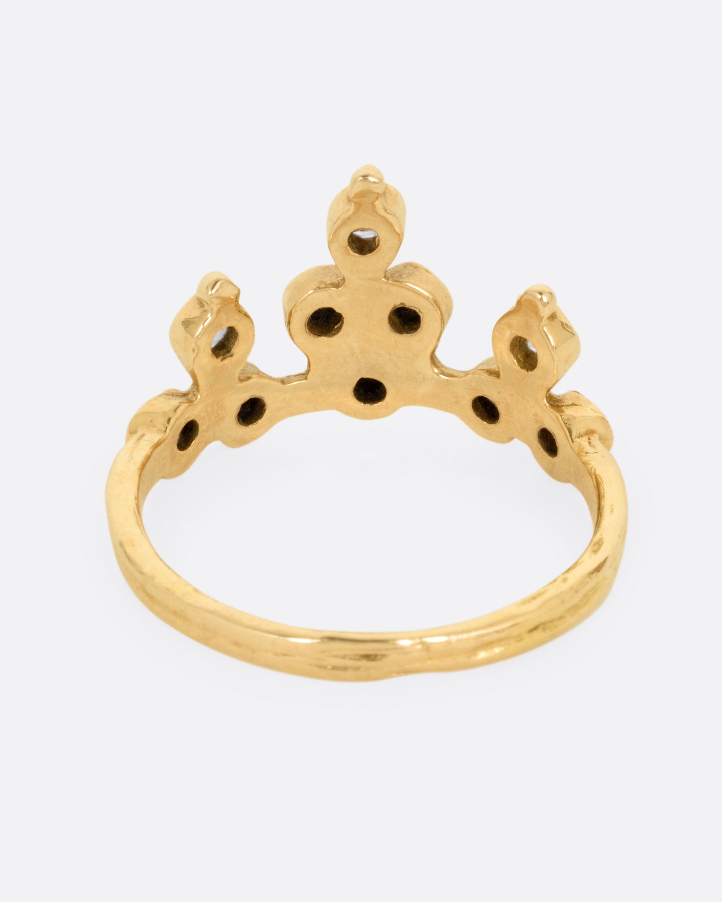 A yellow gold tiara ring with white and black diamonds, shown from the back.