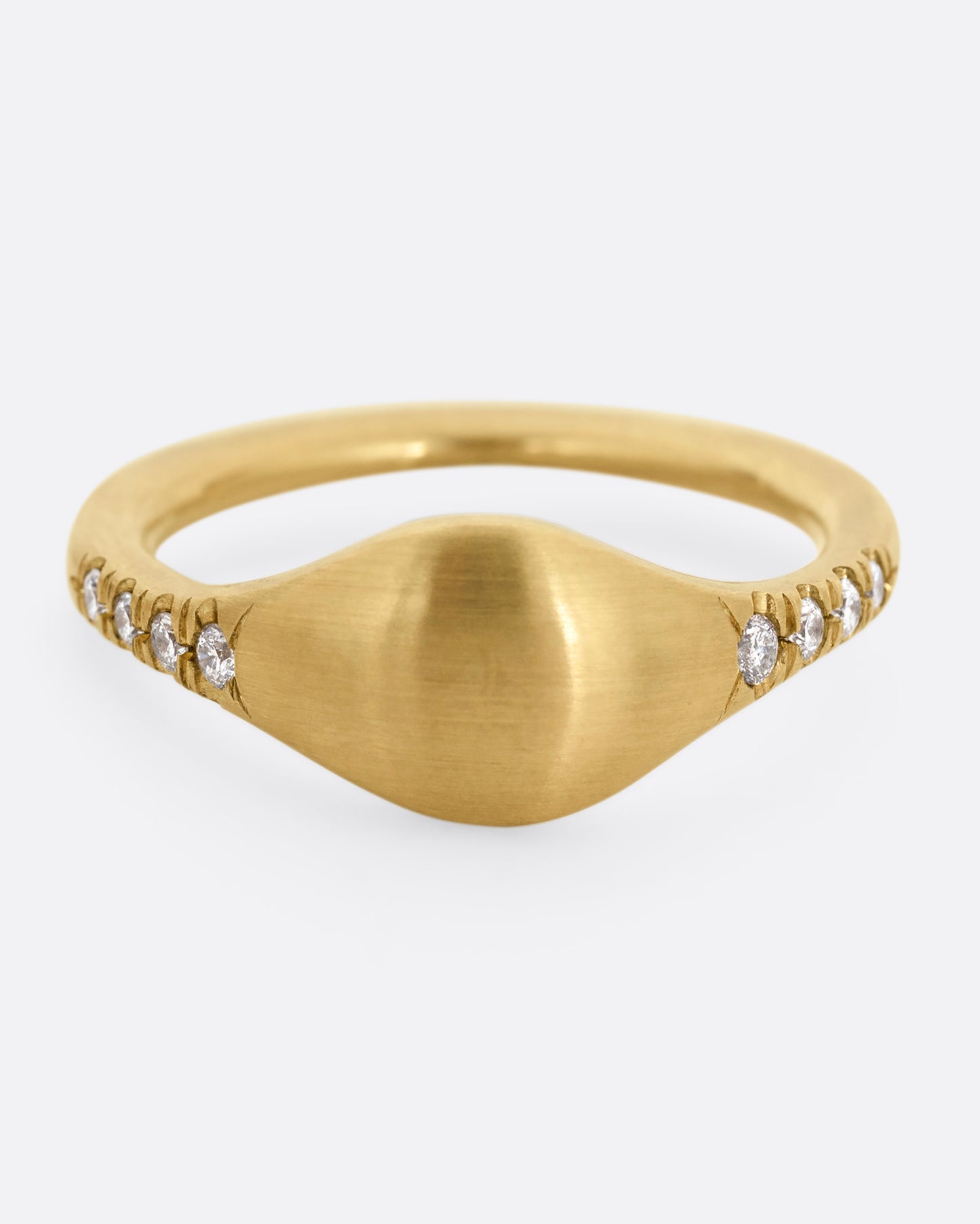 A yellow gold signet ring with diamonds on the shoulders. Shown from the front.