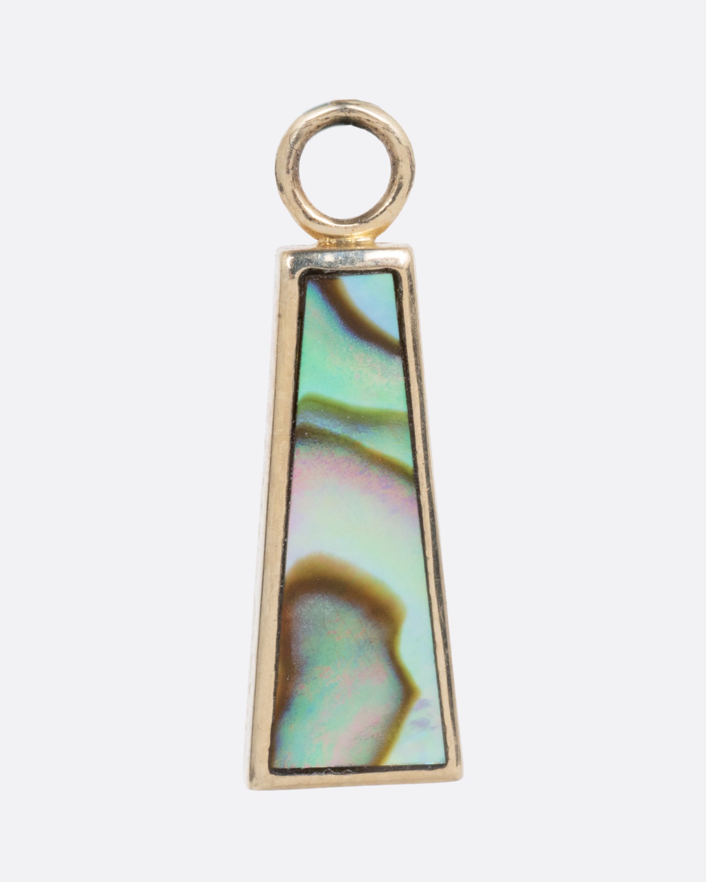 A yellow gold trapezoid dangle with abalone inlay. Shown from the front.