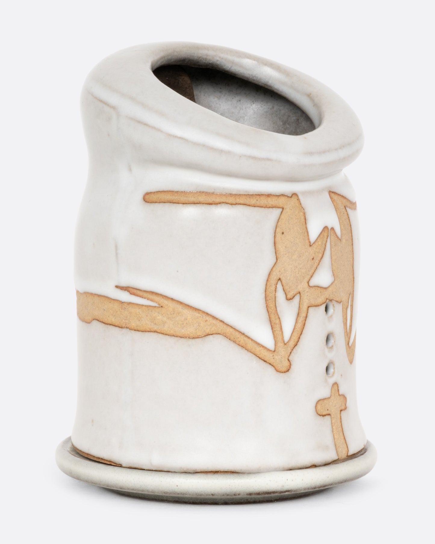 A white ceramic candle holder with a hand carved face of a priest on the inside, and praying arms with a cross on the outside. Shown from the side.