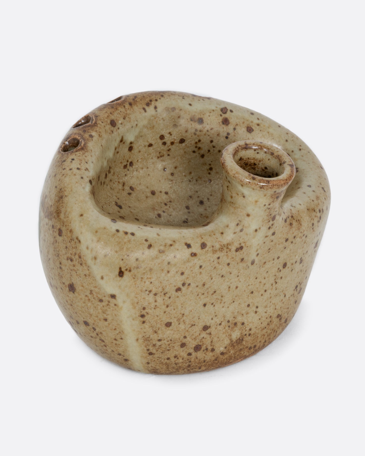 A ceramic bud vase with five small holes for flowers and a cleft at the front with a hand painted floral design. Shown from the side.