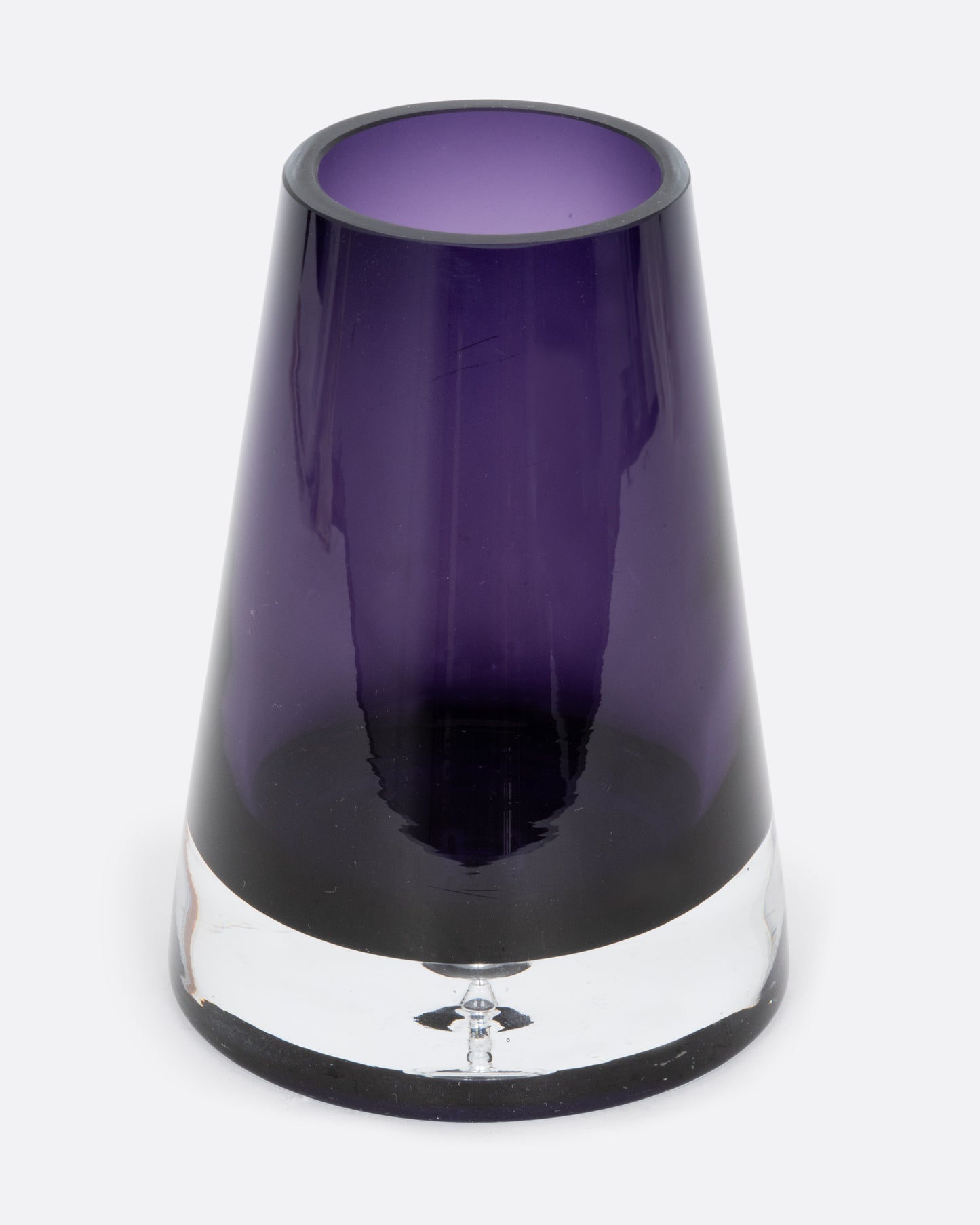 An aubergine glass vase with a wide base and more narrow top. Shown from the front.