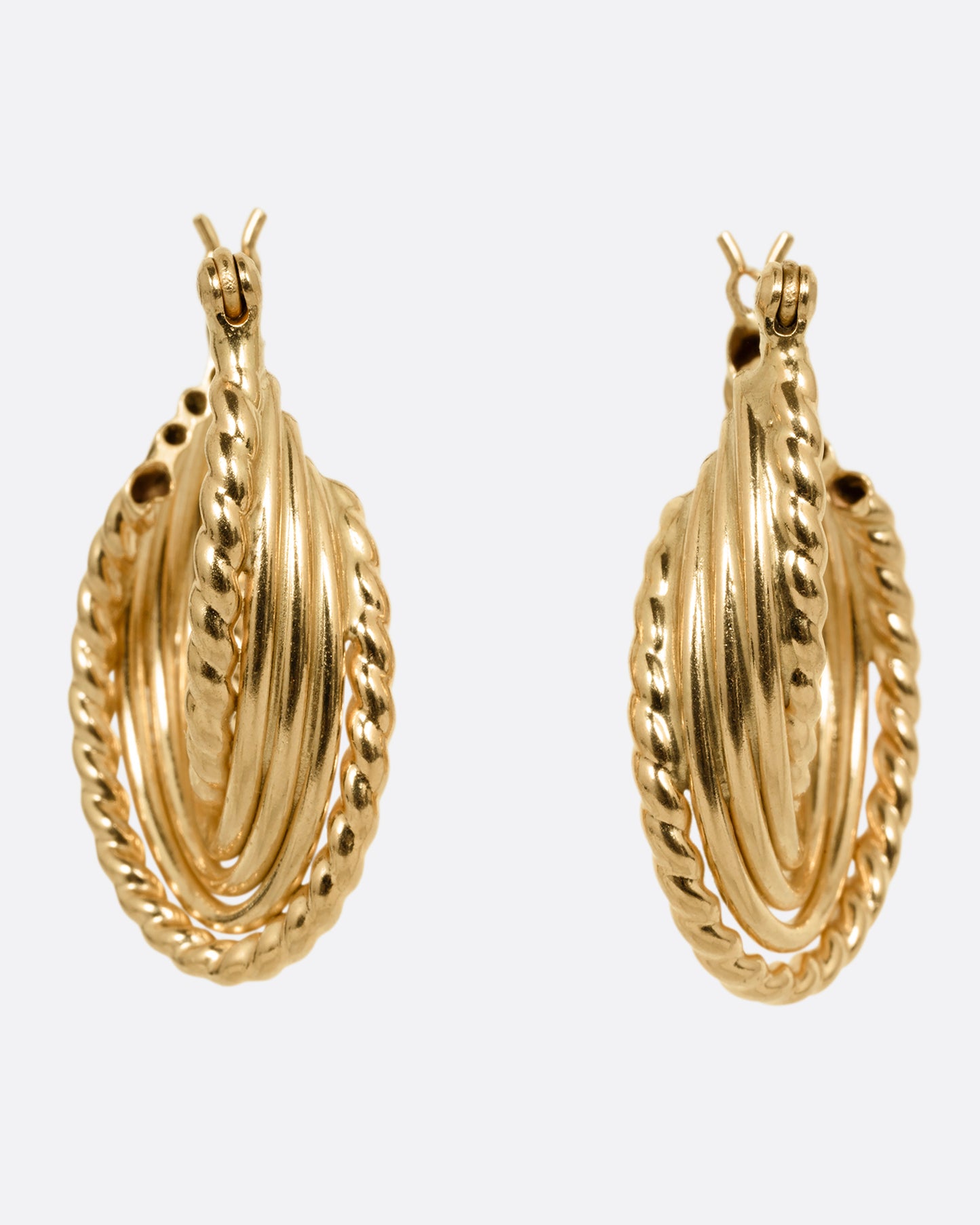 A pair of yellow gold earring with layers of twisted loops and click tops. Shown from the front.
