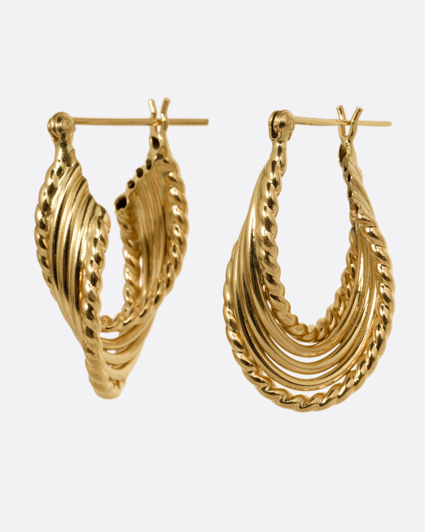 A pair of yellow gold earring with layers of twisted loops and click tops. Shown from the side.