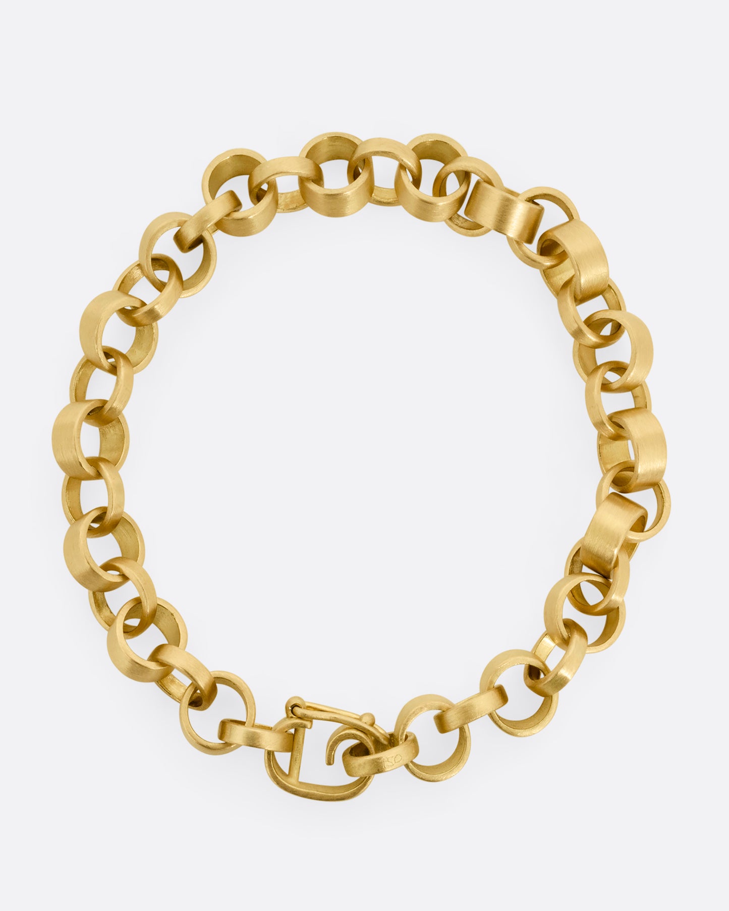 A yellow gold bracelet with bicycle chain inspired links. Shown from the top.