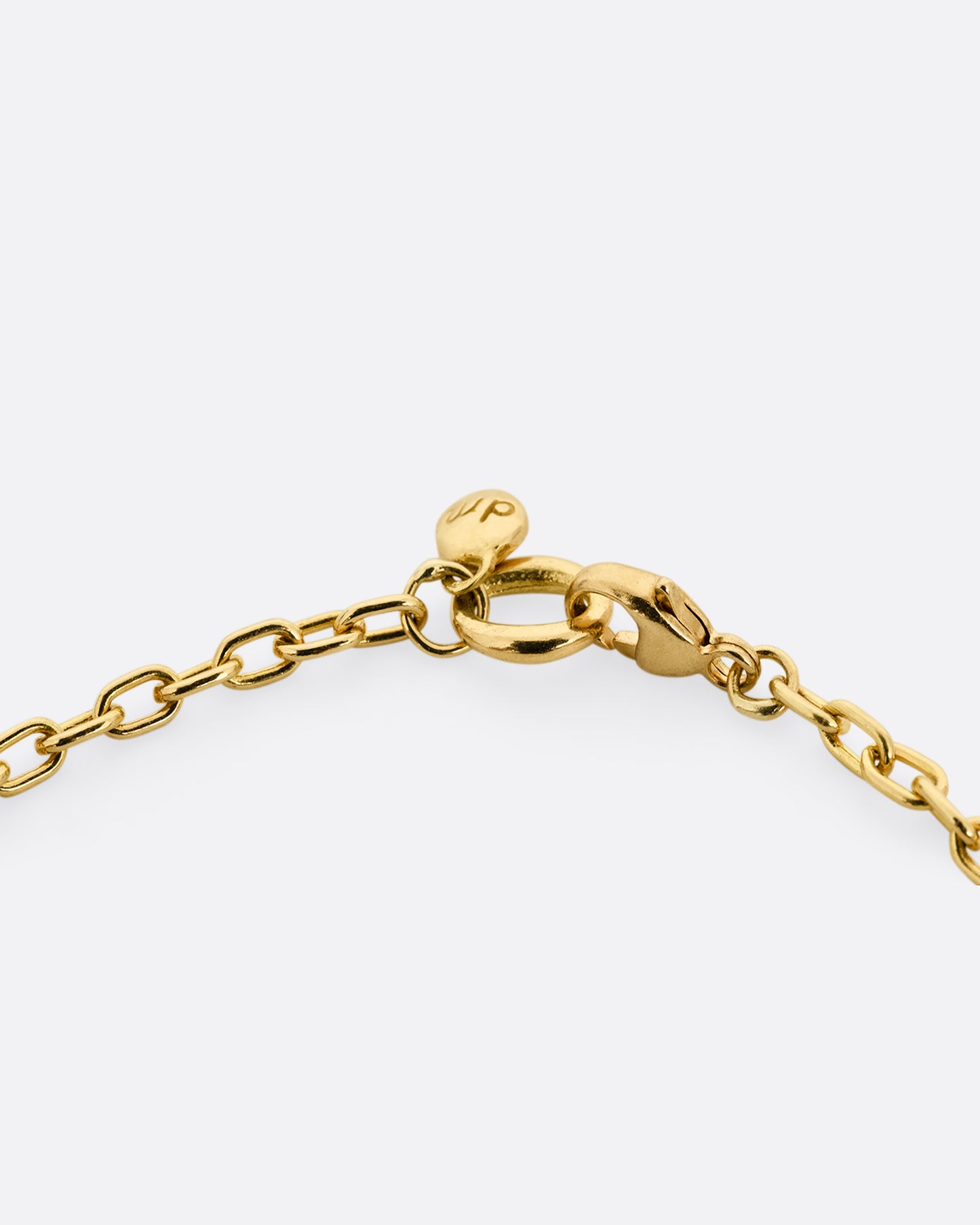 A close up of a yellow gold cable chain and clasp.
