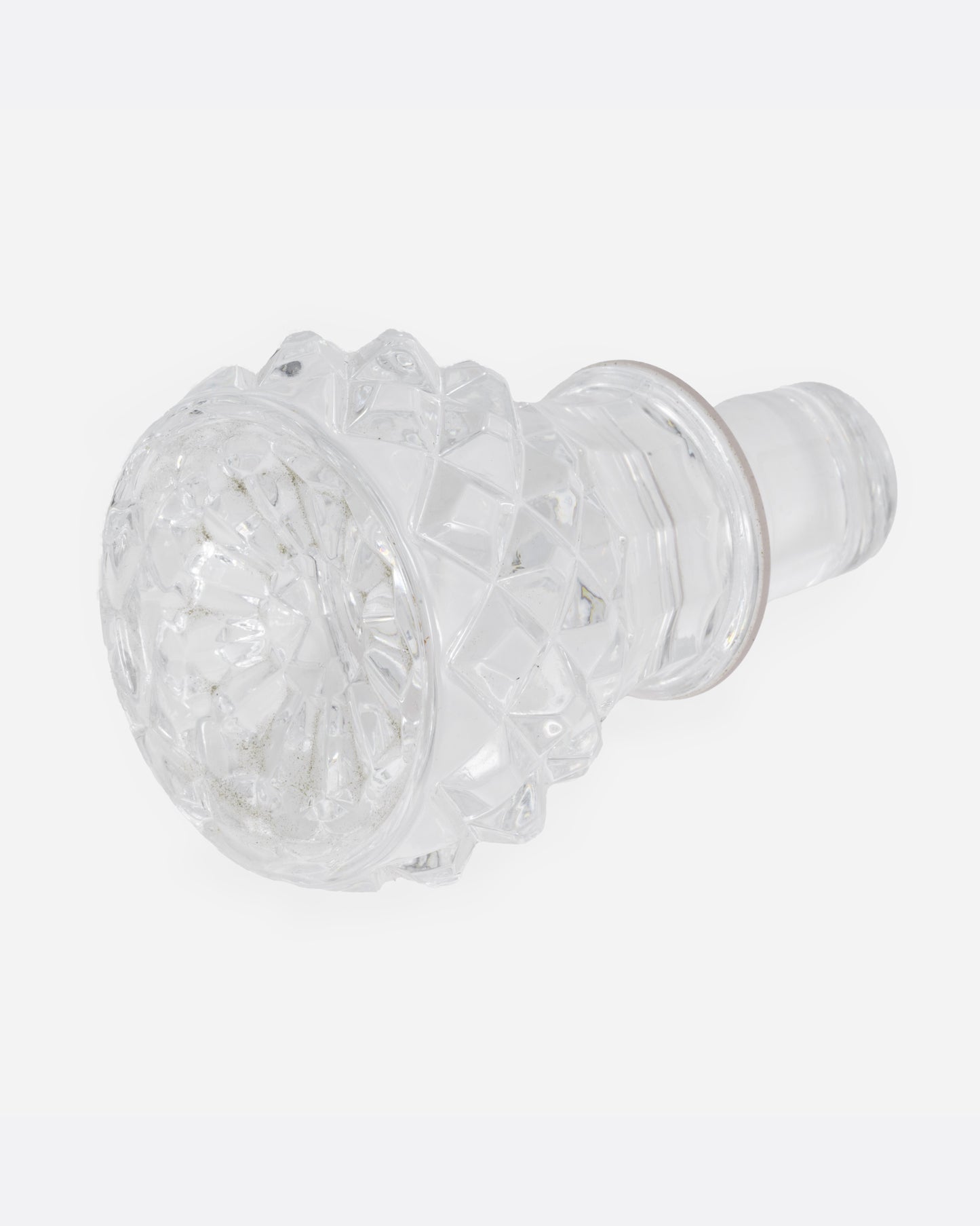 The top of a crystal cut glass decanter, shown lying on its side.