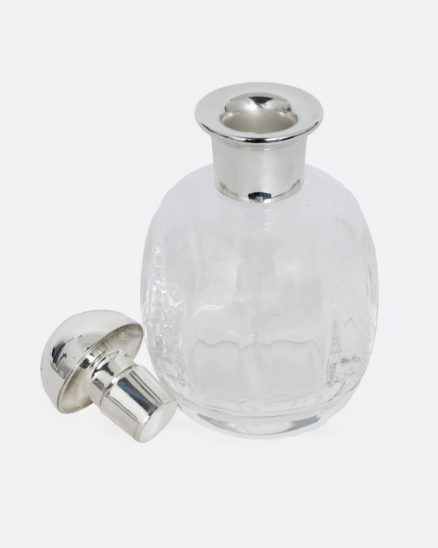 A clear glass decanter with a silver top, shown open from the front.