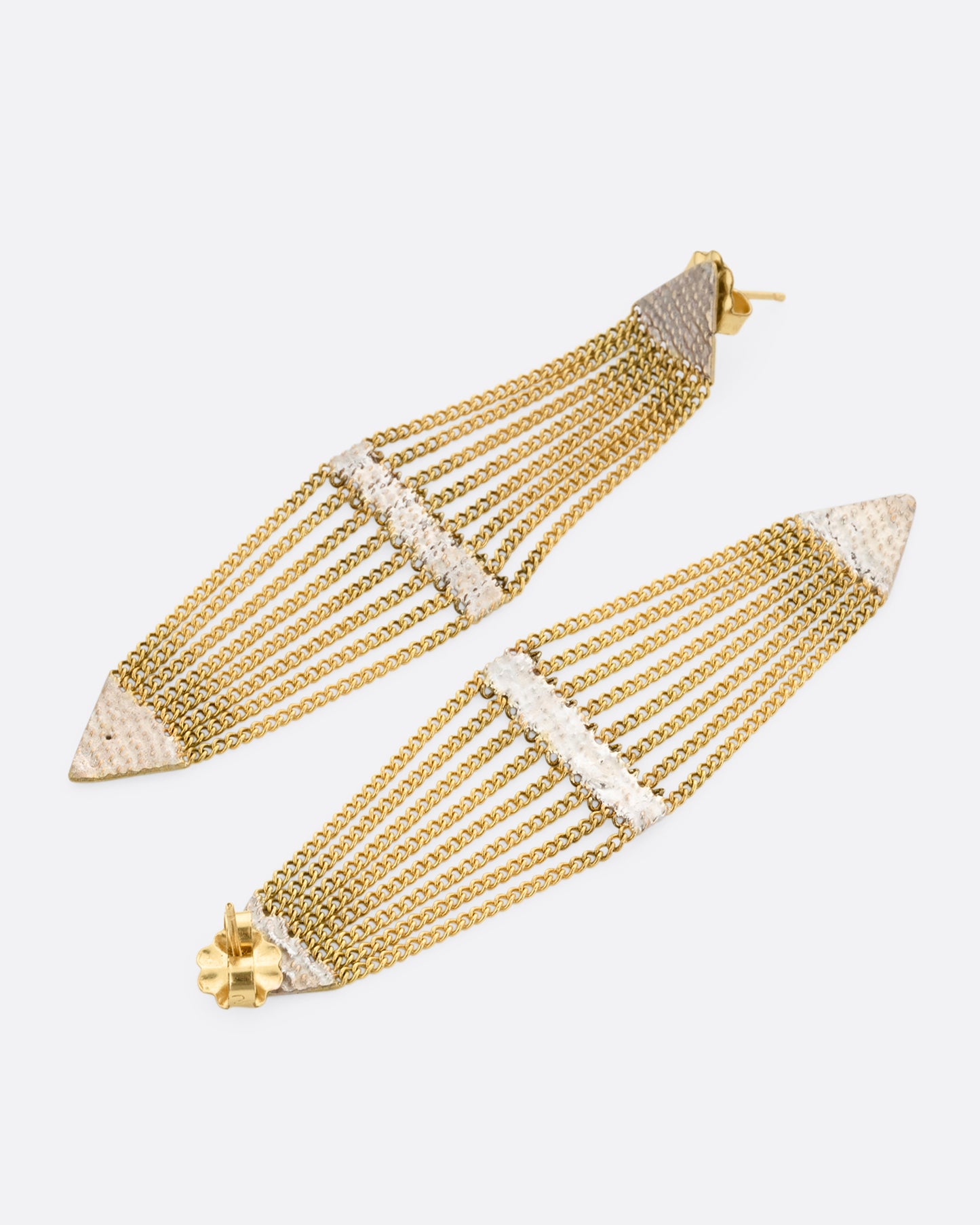 A pair of diamond shaped earrings with silver solder and yellow gold chain. One earring is shown lying flat from the front, the other from the back.