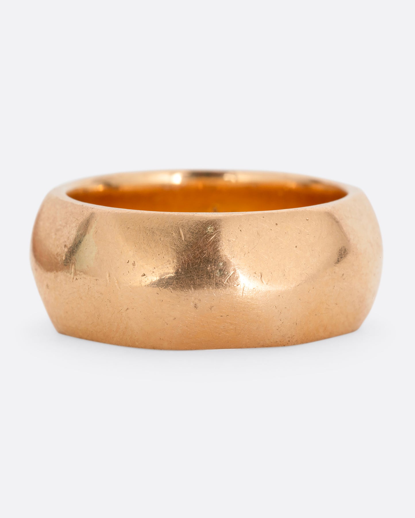 A wide hammered yellow gold cigar band. Shown from the front.