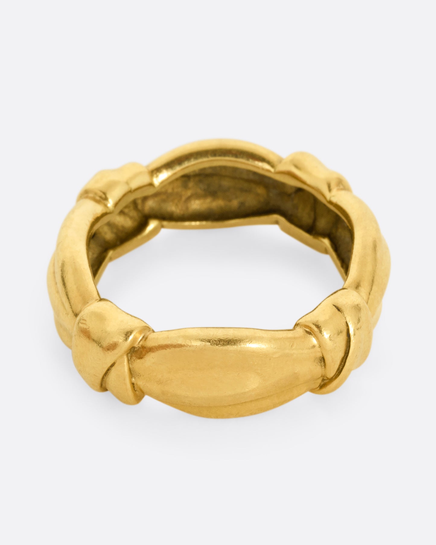 A yellow gold ring with bow knots throughout. Shown from the top.