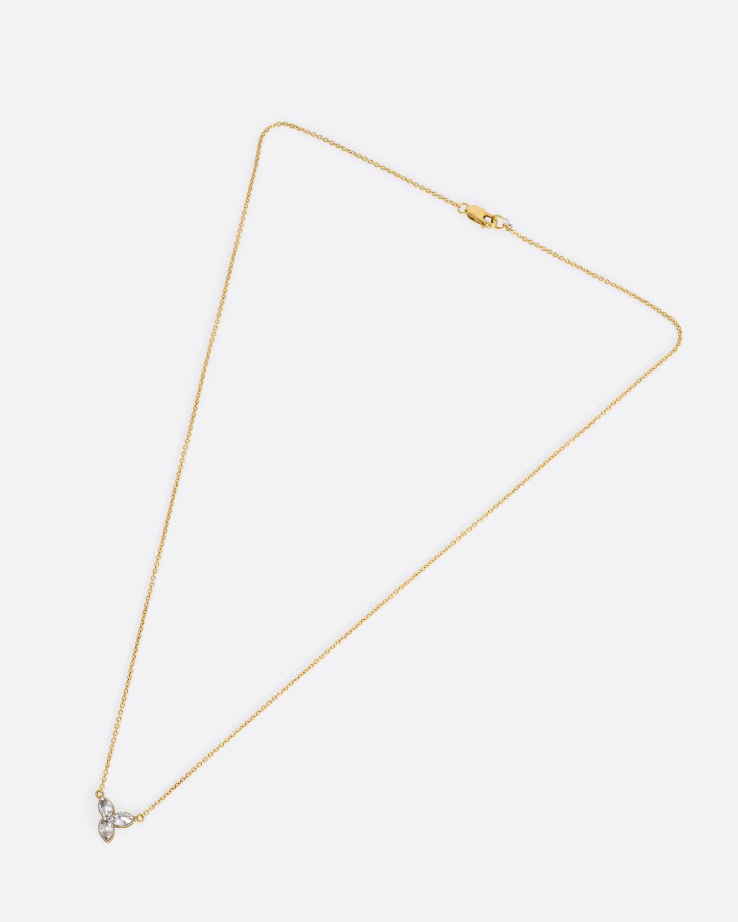 A yellow gold cable chain necklace with a pendant of three inverted marquise diamonds, shown from the front.