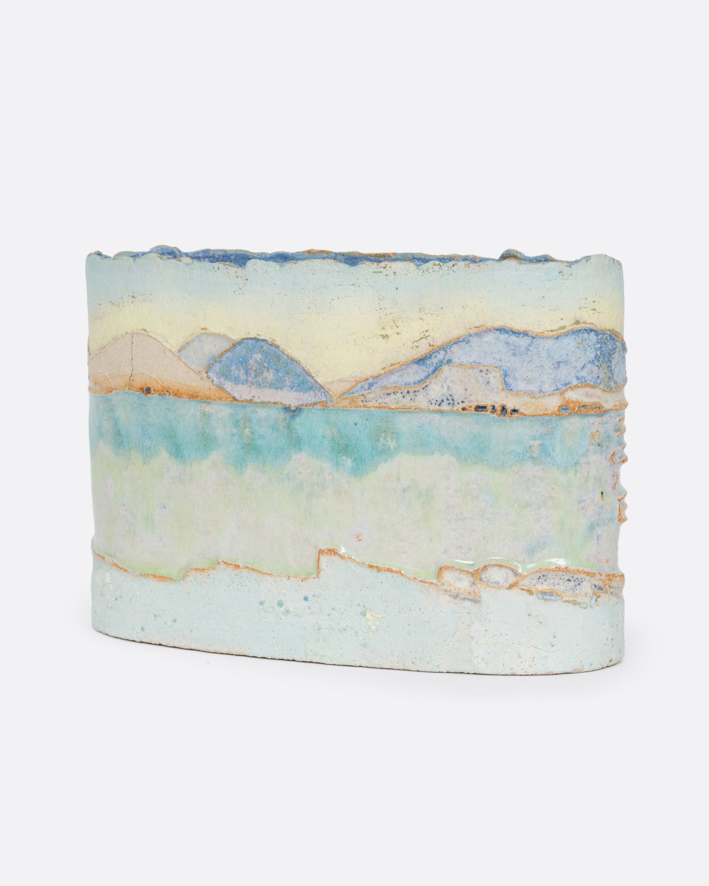 An oblong ceramic vessel with a landscape on it. Shown from the back.
