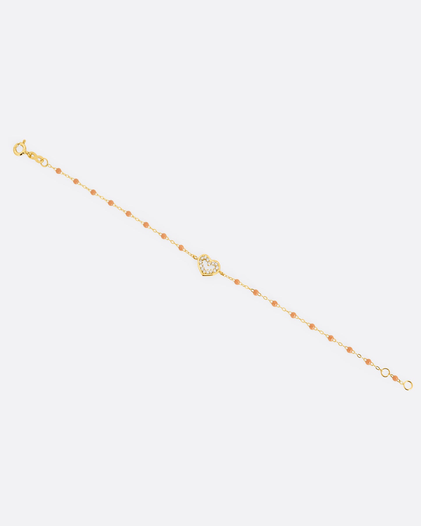A yellow gold cable chain bracelet with a diamond lined heart charm and caramel brown resin droplets throughout. Shown from the front.