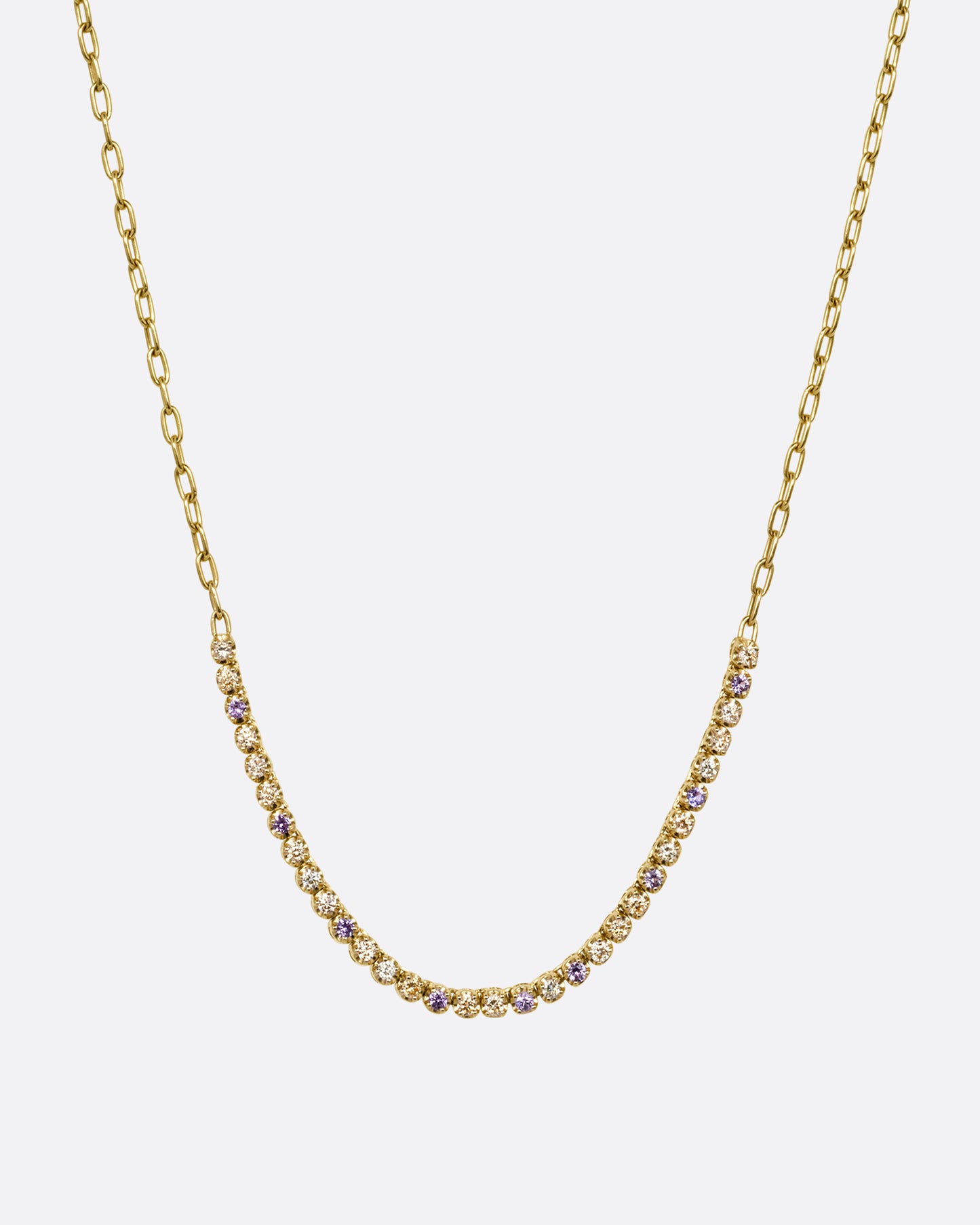 A yellow gold cable chain necklace with peach and yellow diamonds and purple sapphires in a 'partial tennis' setting. Shown from the front.