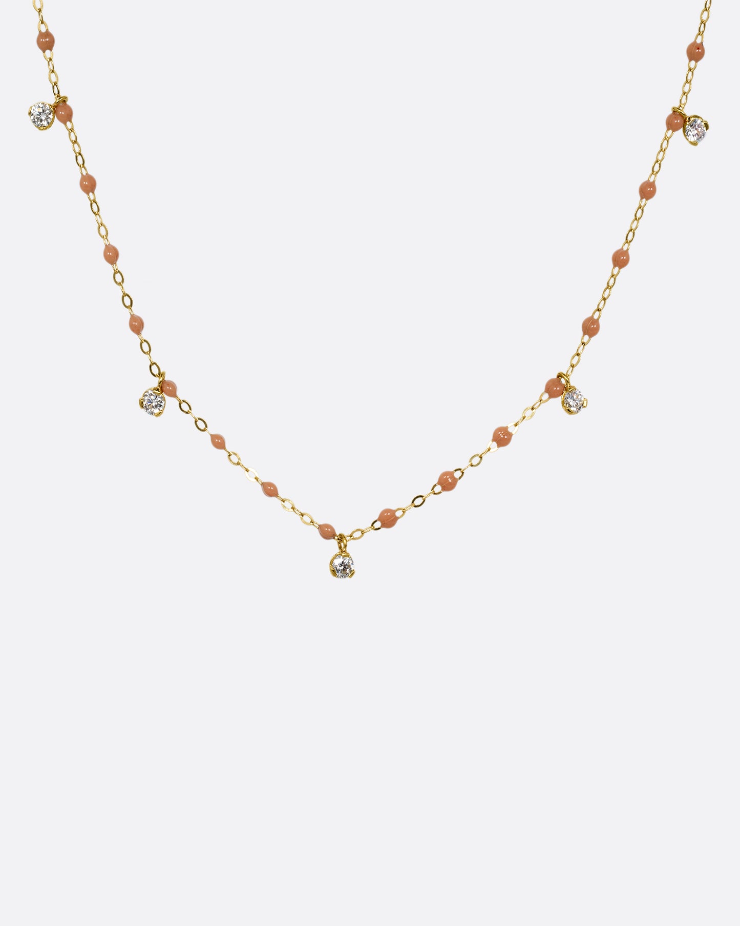 A yellow gold cable chain necklace with caramel brown resin droplets along the chain and five dangling diamond charms. Shown from the front.