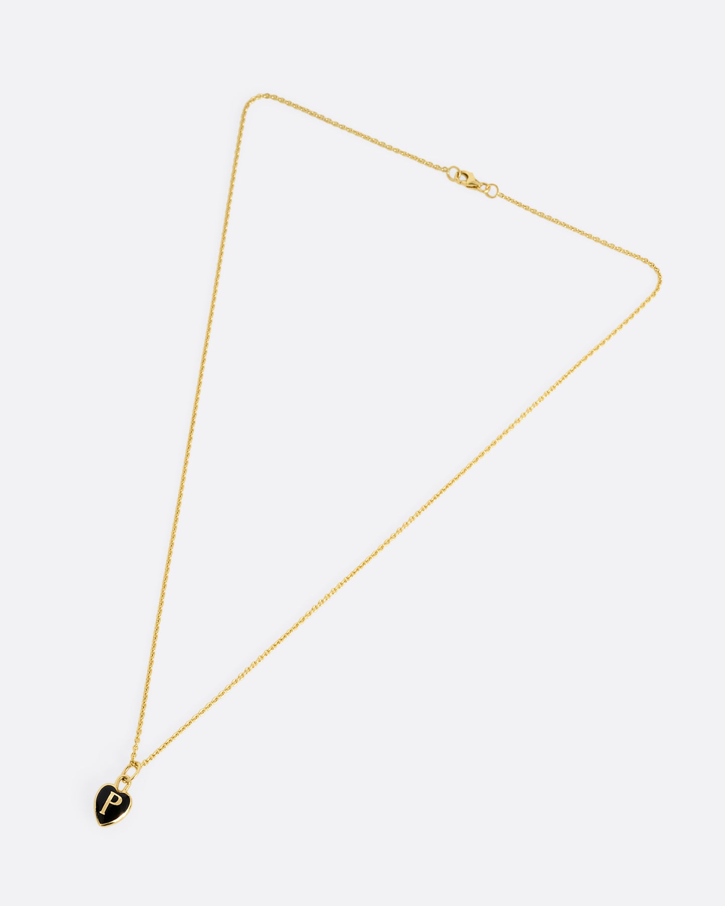 A yellow gold cable chain necklace with a black enamel 'P' heart pendant. Shown closed lying flat at an angle from the front.