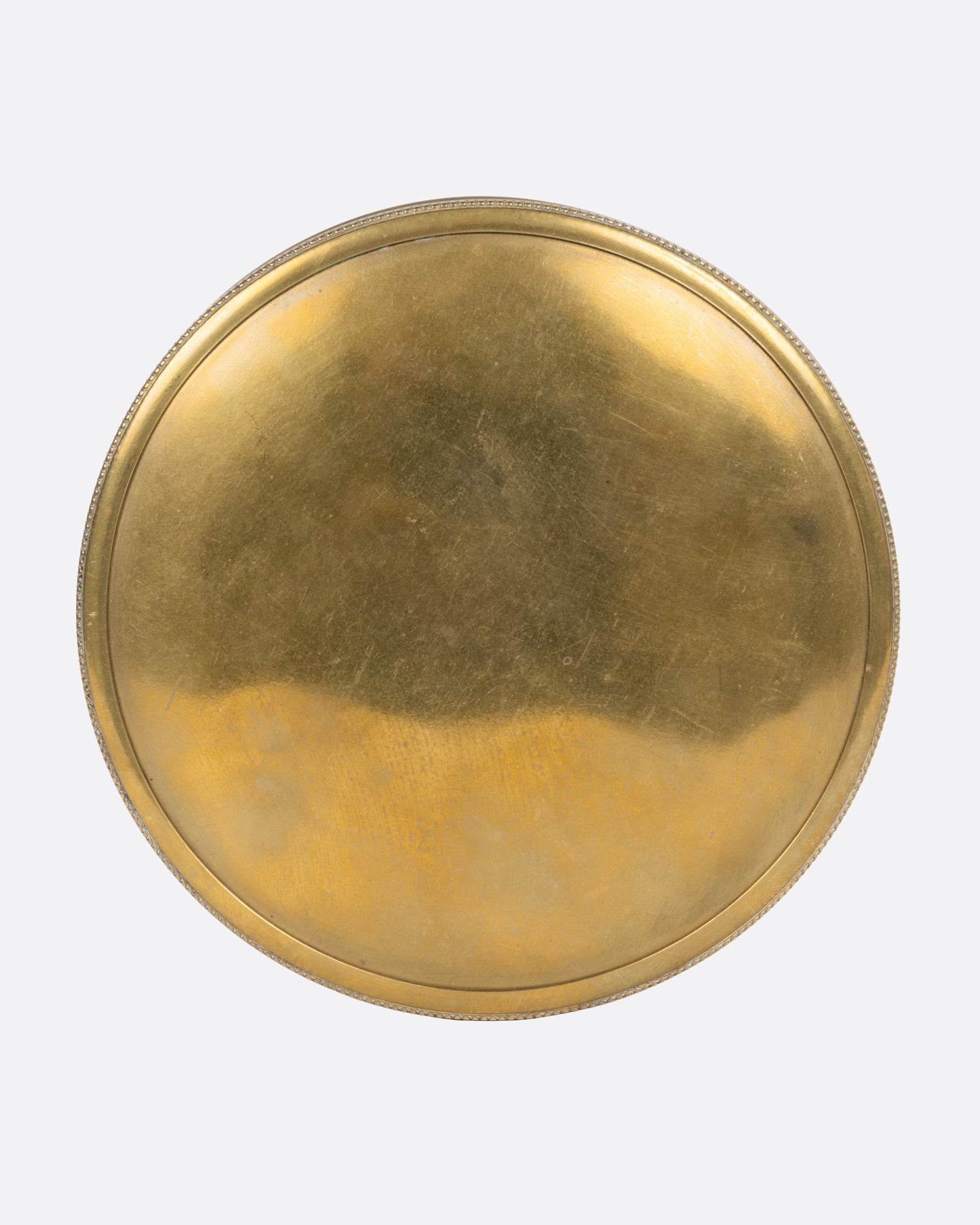A circular brass box with a lid, shown from the top.