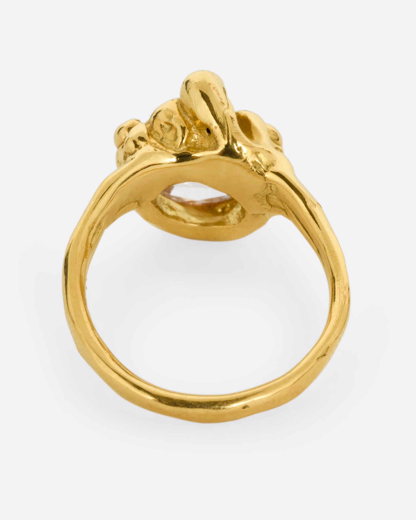 A yellow gold ring with a central rose cut diamond half moon and bezel set diamond accents on top of the flat side. Shown from the back.