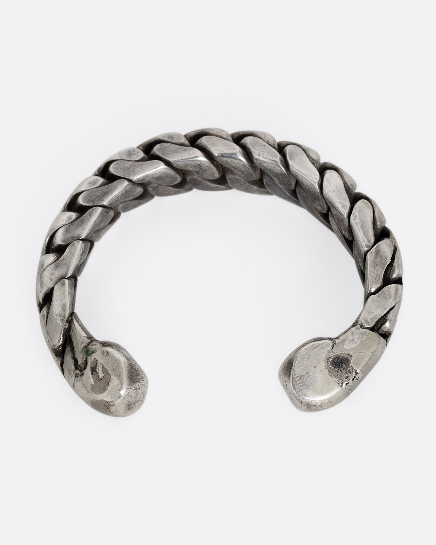 A silver curb chain cuff bracelet, soldered stiff with an open back. Shown from the back.