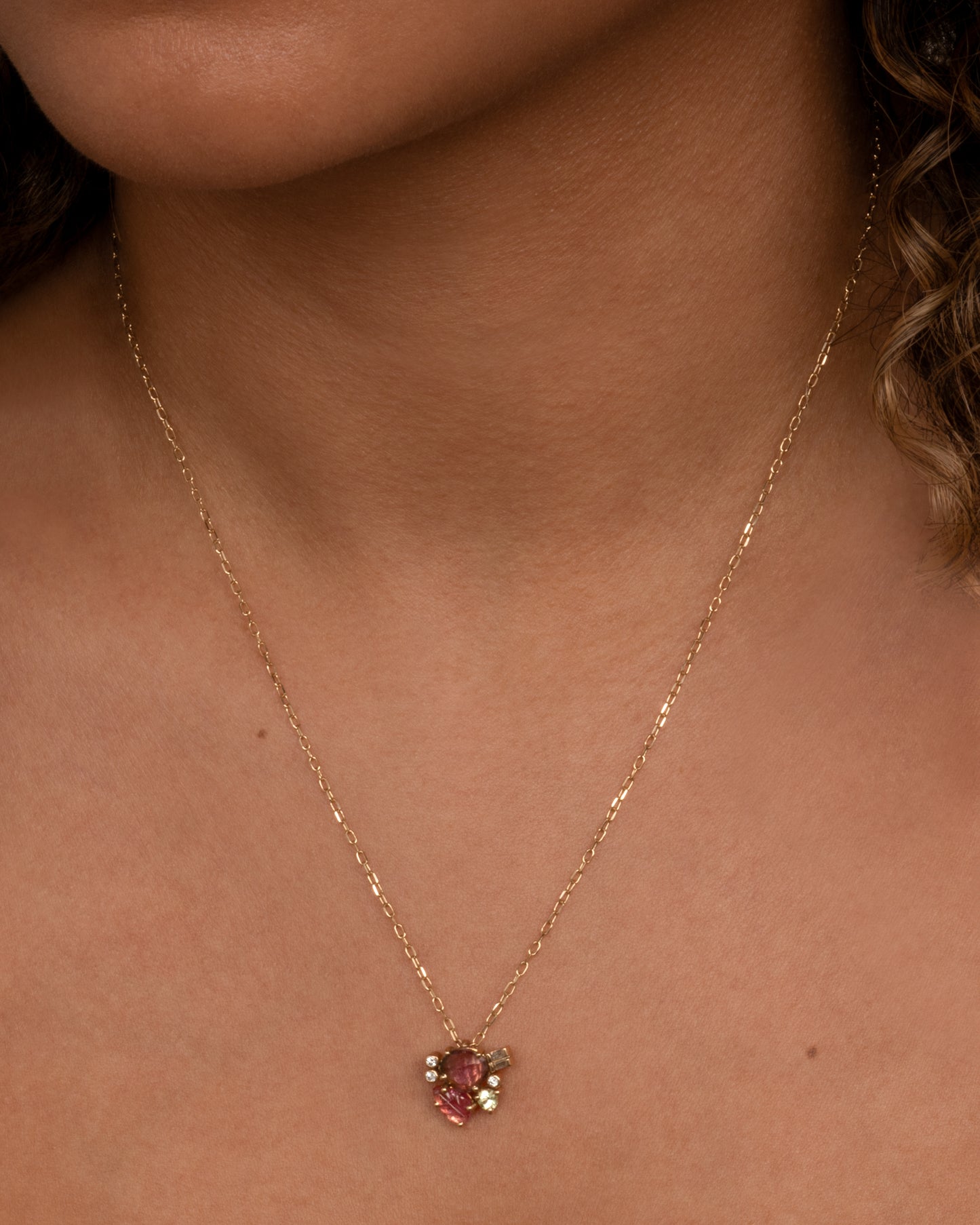 This cluster pendant features a pink tourmaline leaf and diamond accents. Shown worn on a chain in a slightly different colorway.