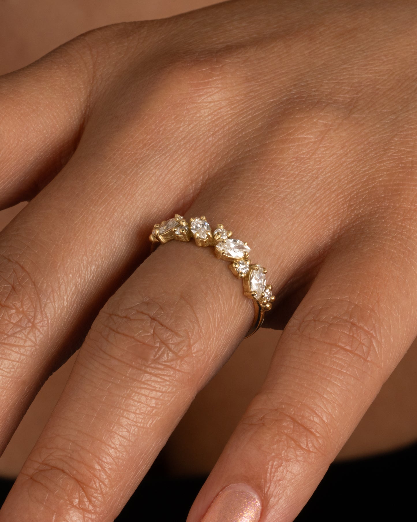 A half-band of round and marquise diamonds. Shown worn on hand.