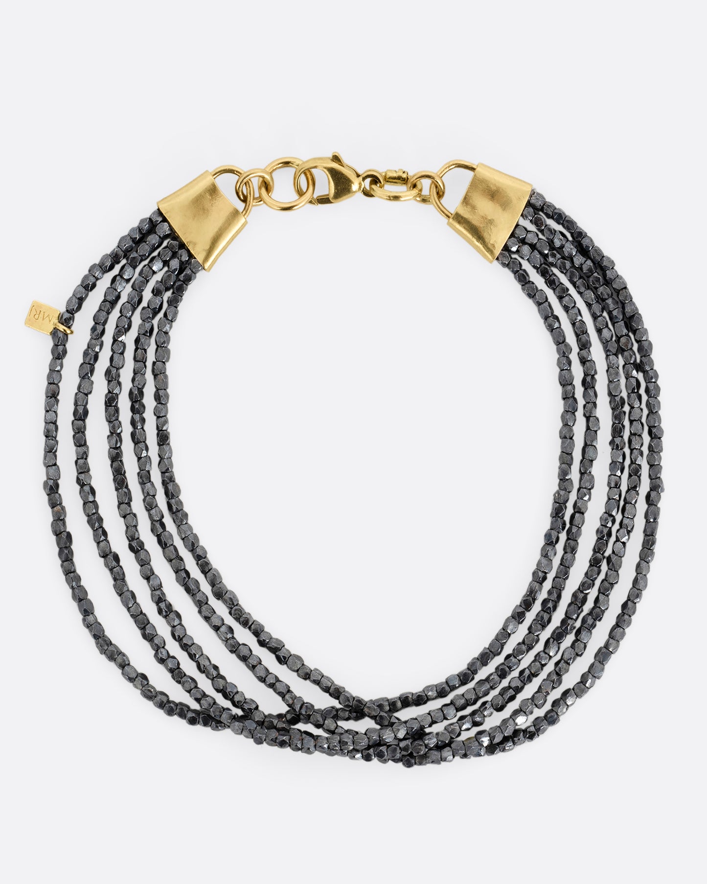 A bracelet with five strands of oxidized silver beads converging at yellow gold capped ends with a lobster clasp. Shown from the top.