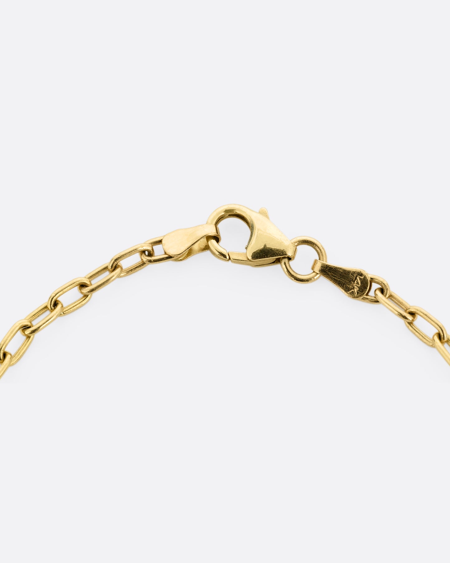 A close up on a yellow gold bracelet clasp.