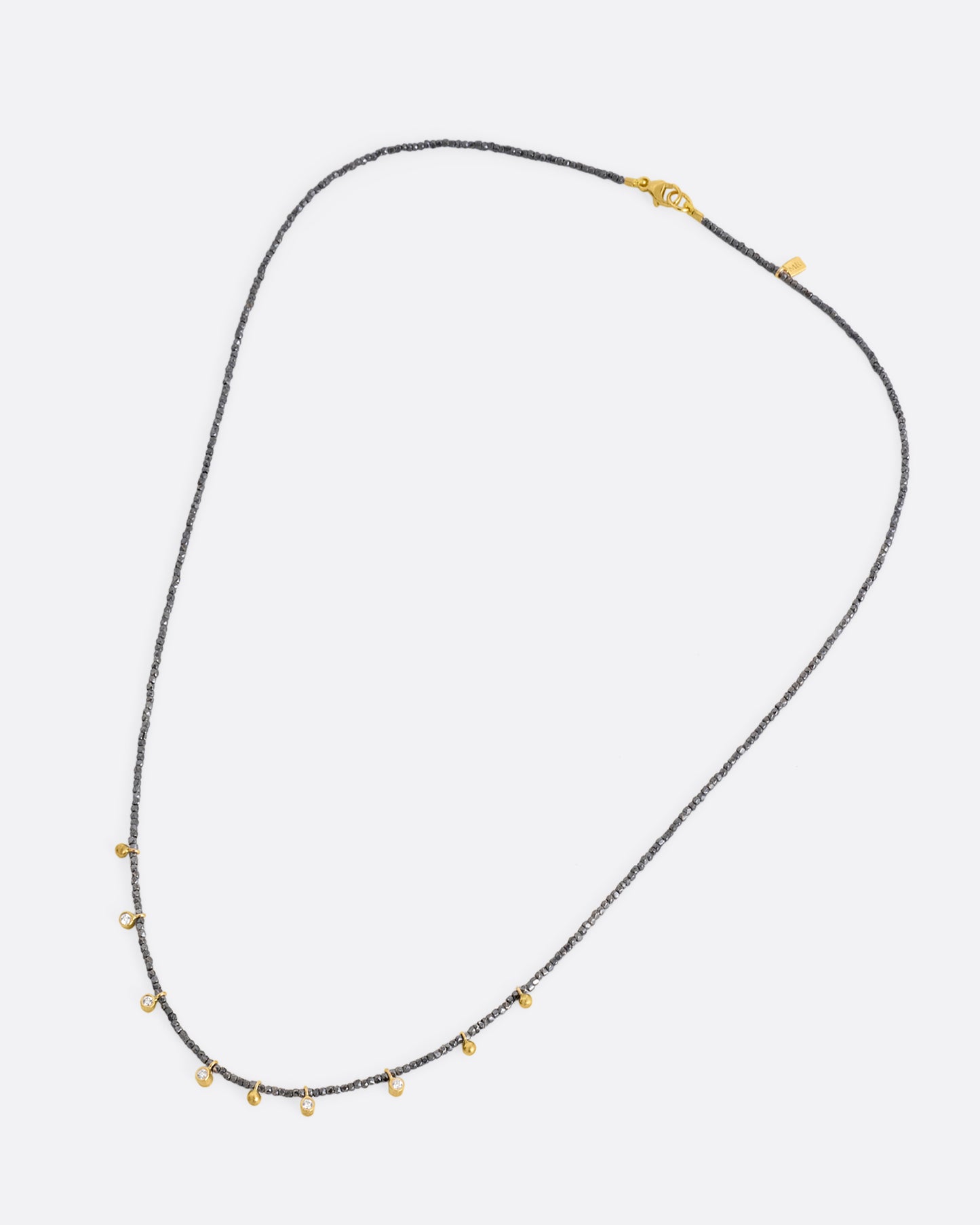A necklace with five bezel set diamond charms and four gold drops interspersed among oxidized silver beads. Shown from the front.