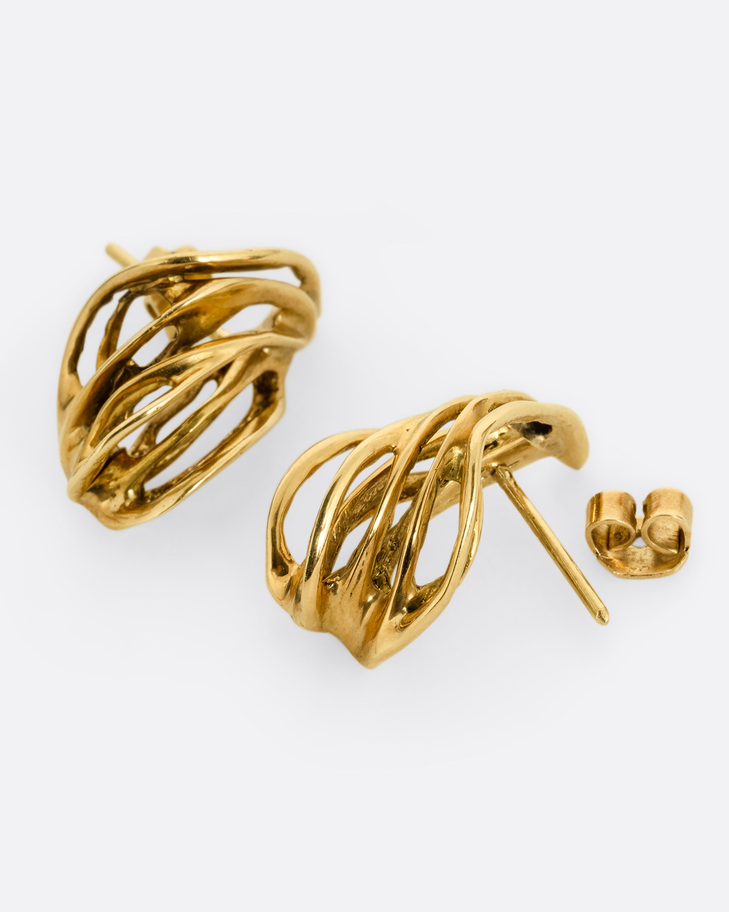 A pair of yellow gold stud earrings with clusters of intertwined gold strands. One earring is shown from the front, the other is shown open from the side.