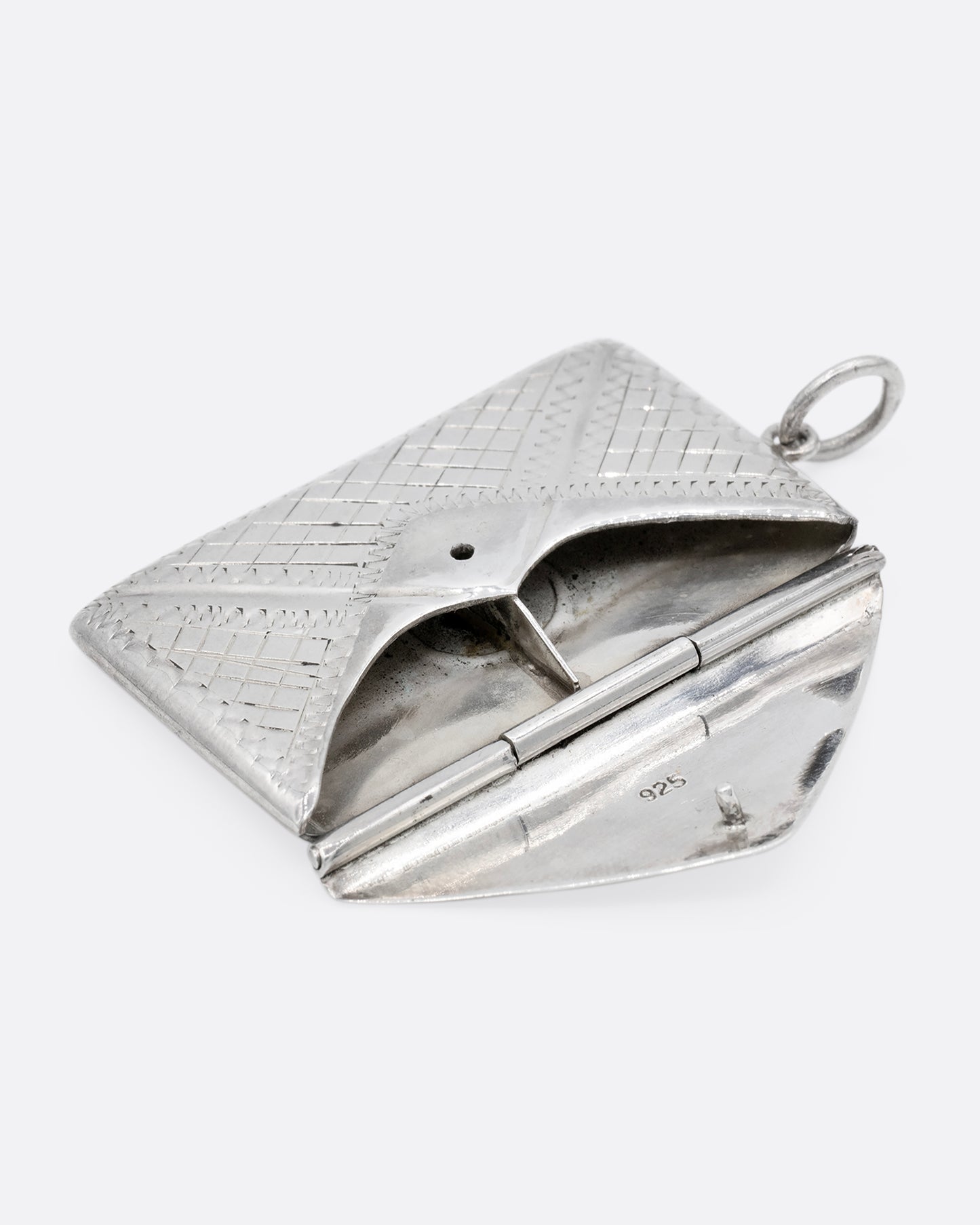 A silver textured envelope locket. Shown open lying flat from the front.