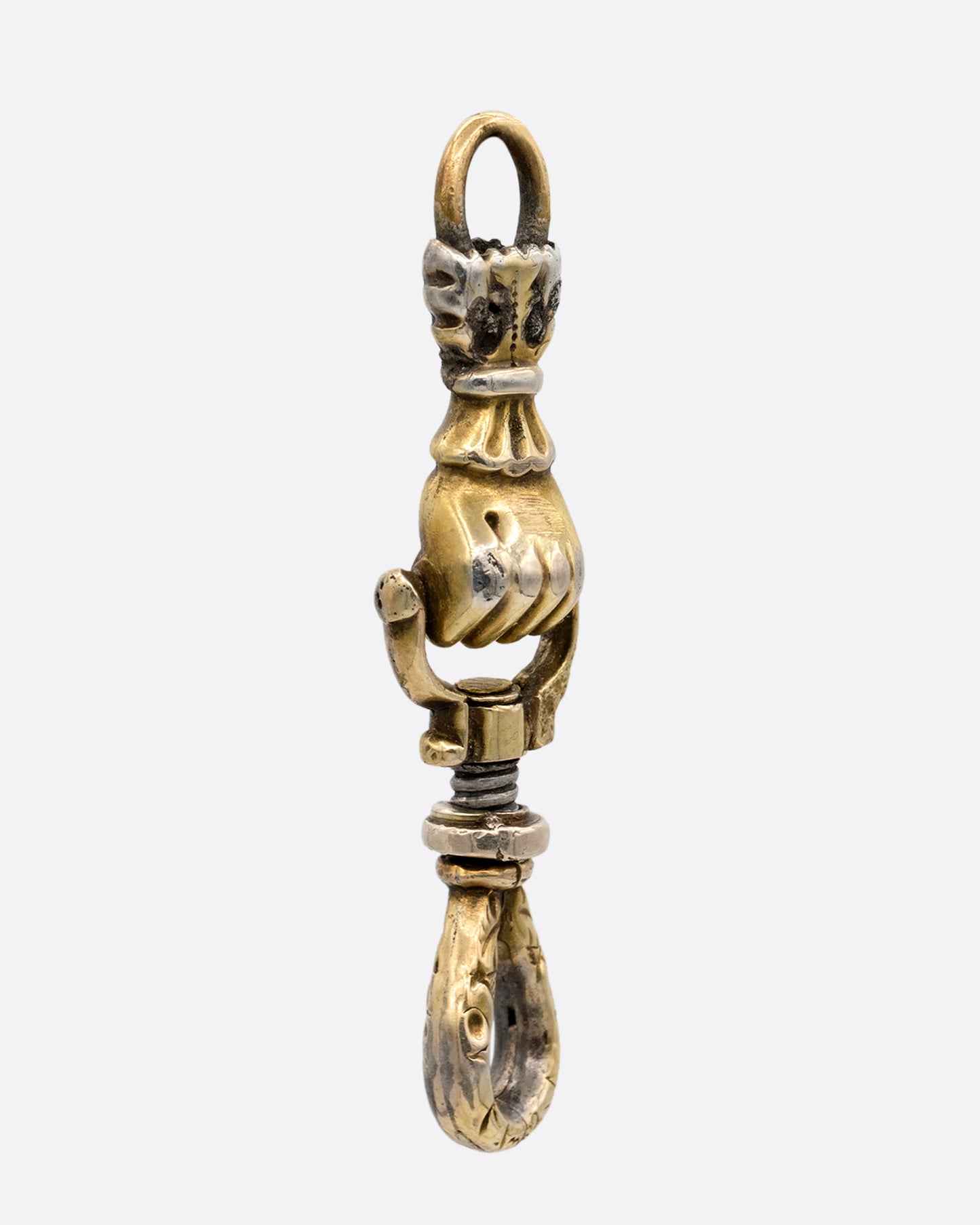 A yellow gold charm holder with a 'knocker' style hand in a fist between each looped end. shown from the side.