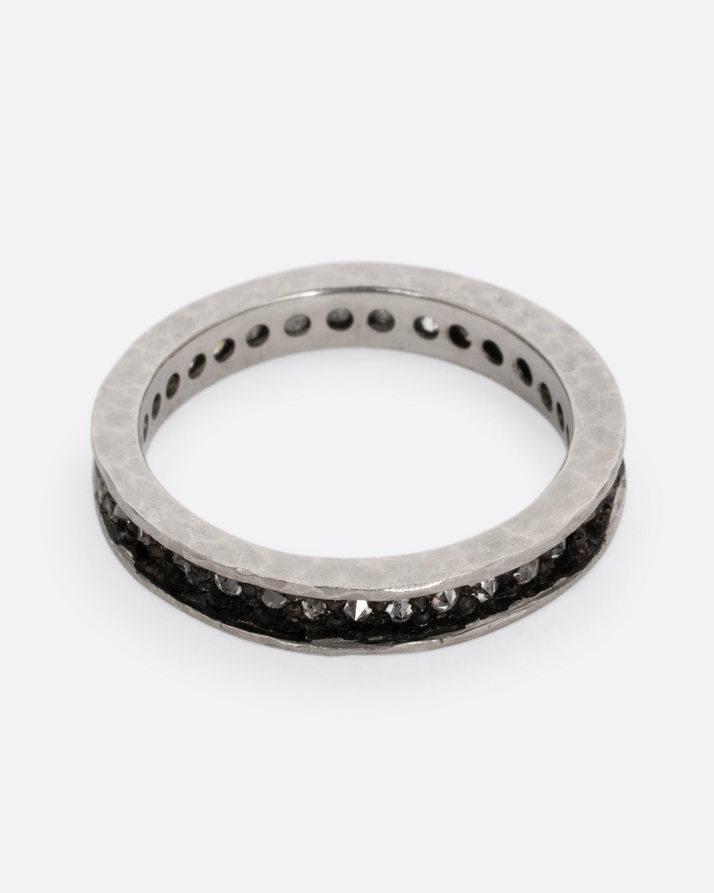 A palladium ring with a queue of diamonds set in a darkened center channel. Shown from the front.