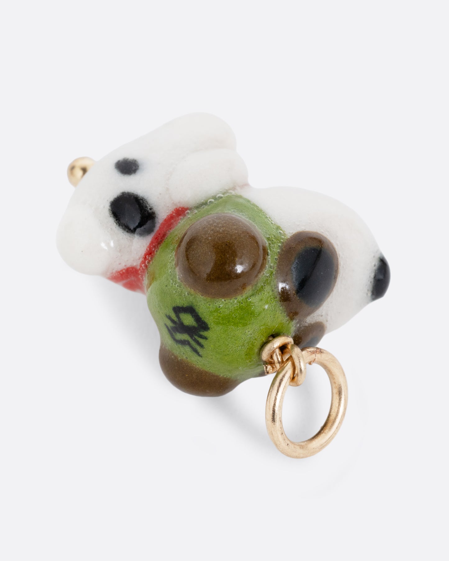 A porcelain Snoopy charm with flight goggles and hat. Shown from the back on its side.