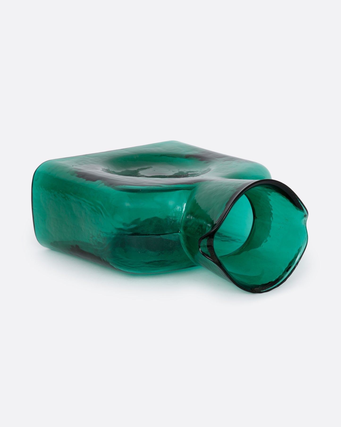 A green glass double spouted 'water bottle' from Blenko. Shown lying on its side from the top.