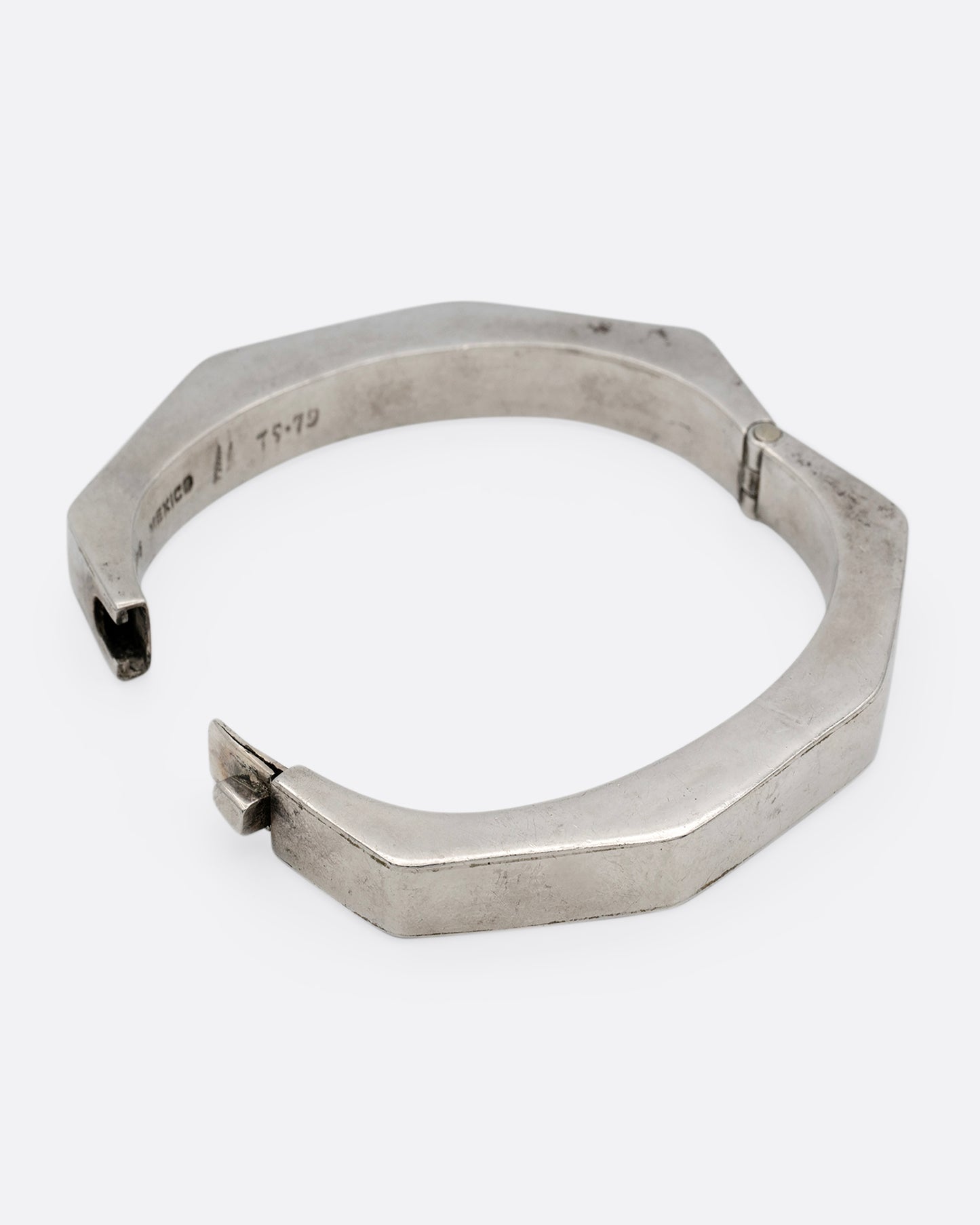 A silver octagonal bangle bracelet, shown open from the side.