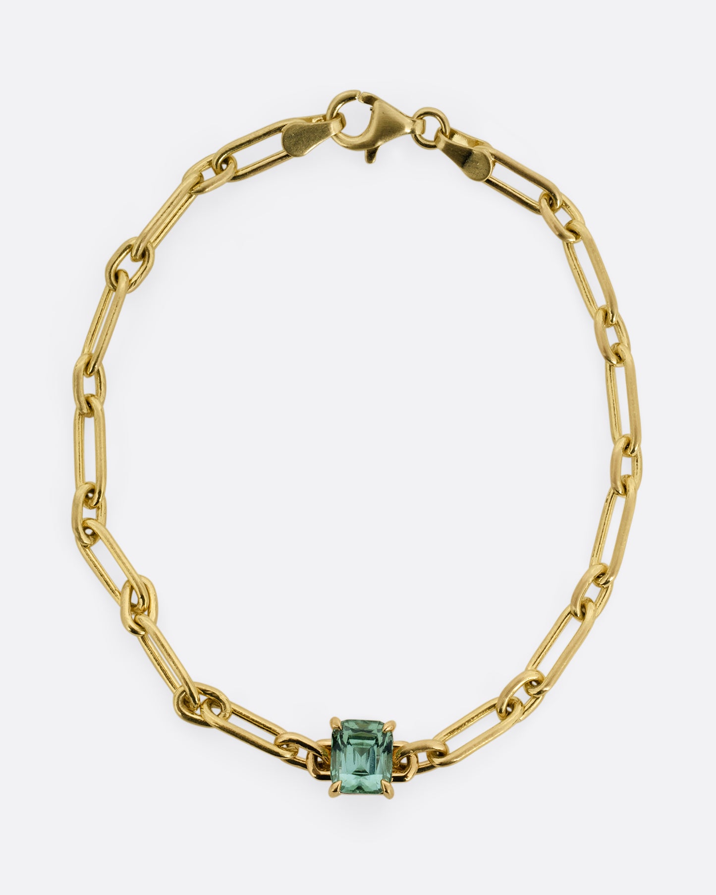A yellow gold chain link bracelet with a prong set aqua tourmaline at the center. Shown from the front.
