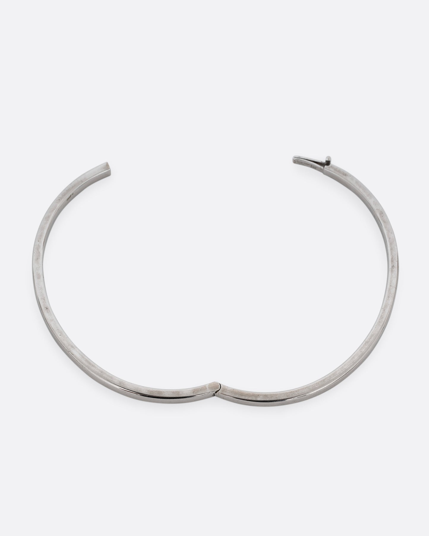 A silver hinged bangle bracelet with squared edges. Shown open from the top.