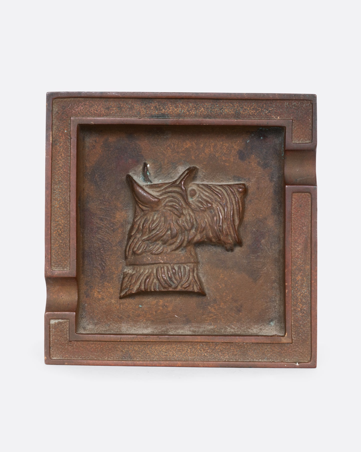 A square brass ashtray with a dunhill Scottie and a cork bottom. Shown from the top.