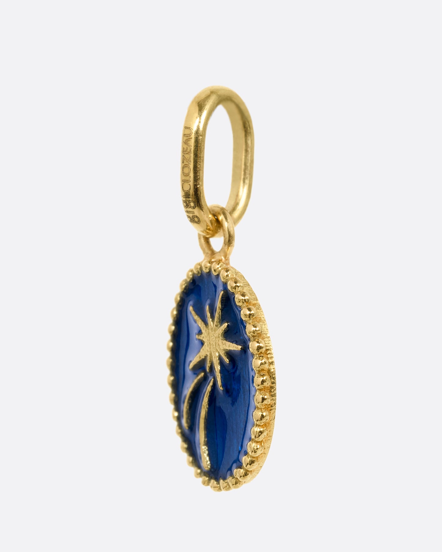 A yellow gold and blue enamel shooting star pendant. Shown from the side.