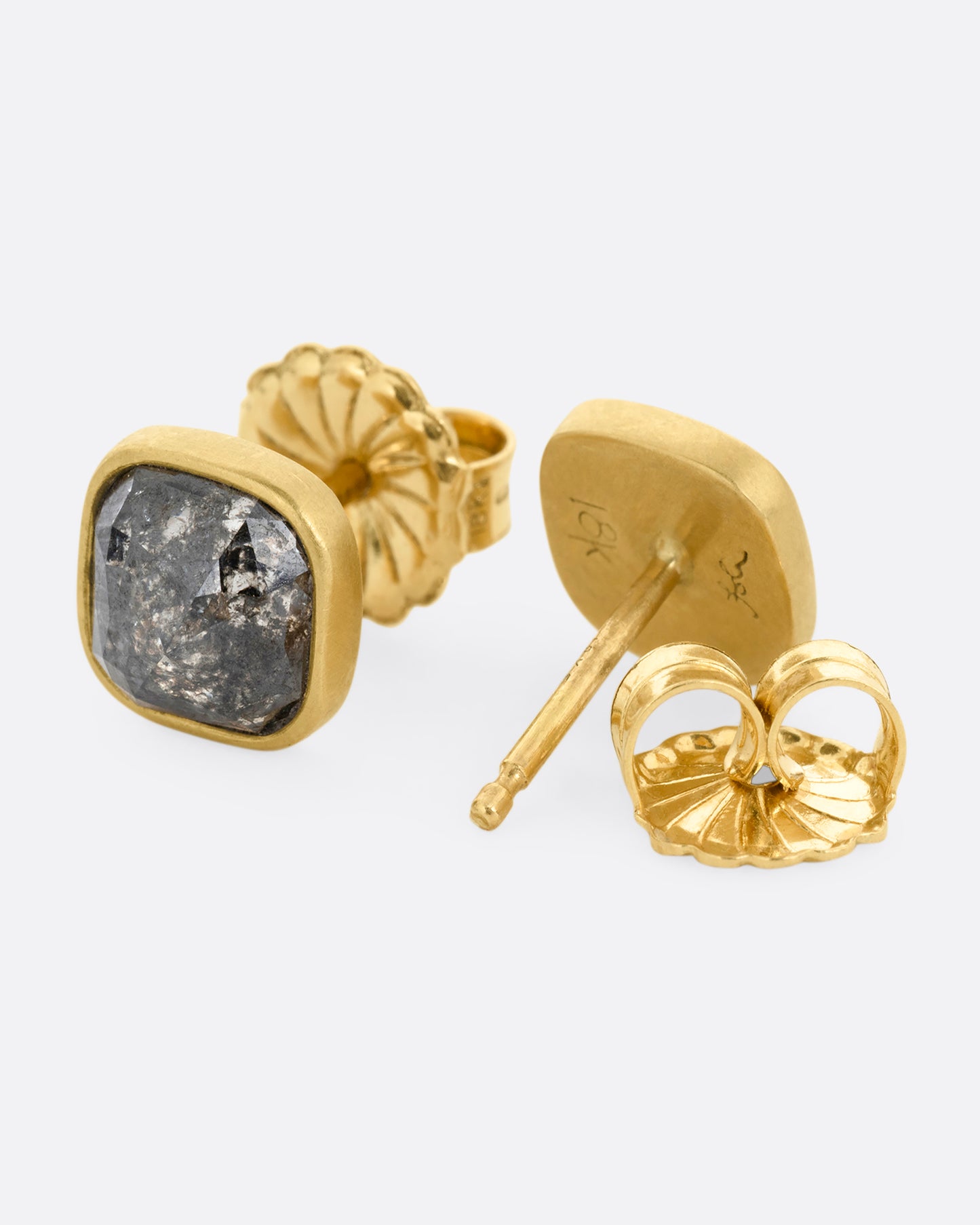 A pair of yellow gold square salt and pepper stud earrings. One earring is shown from the front, the other open from the back.