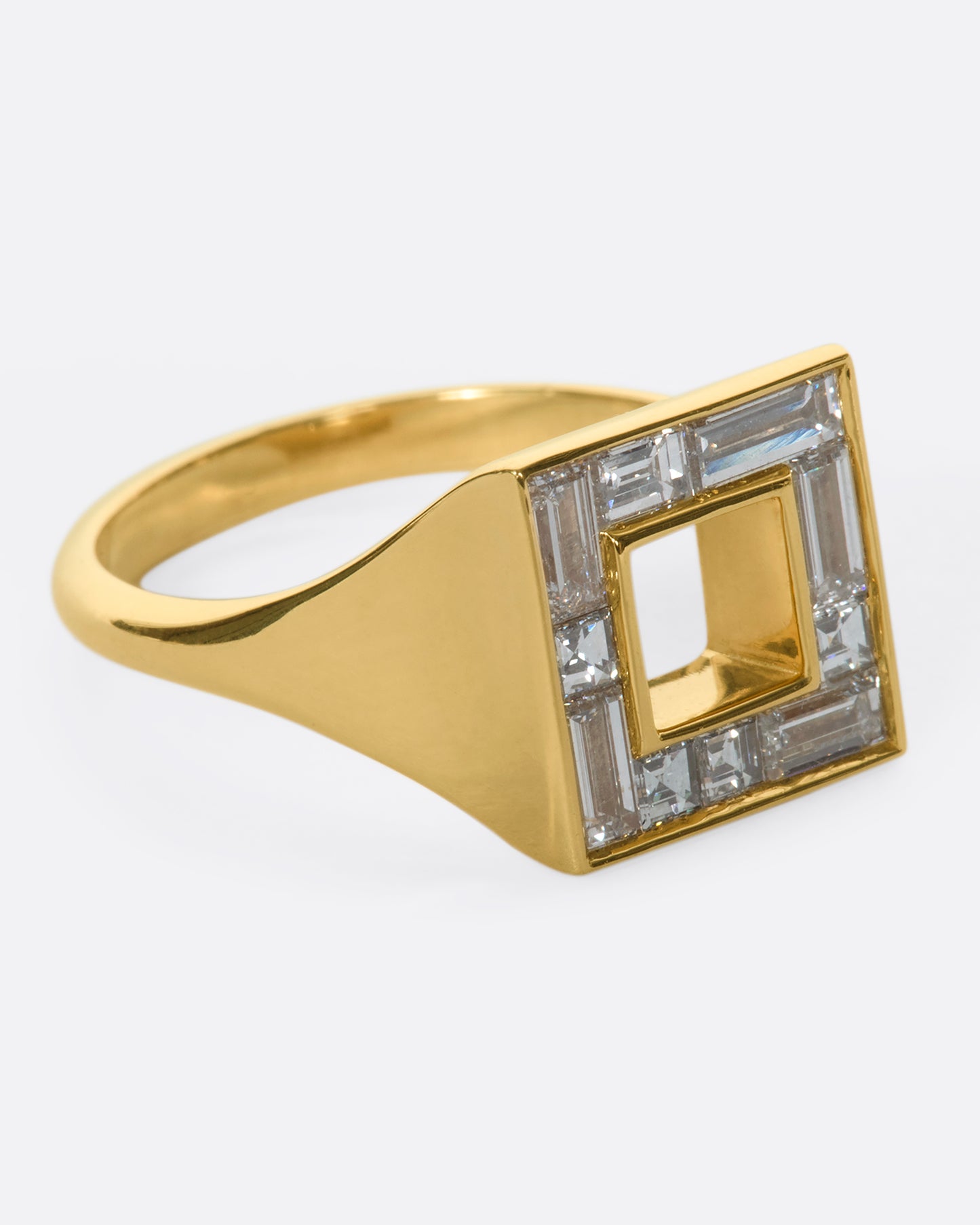 A close up of the right side of a square ring set with baguette diamonds.