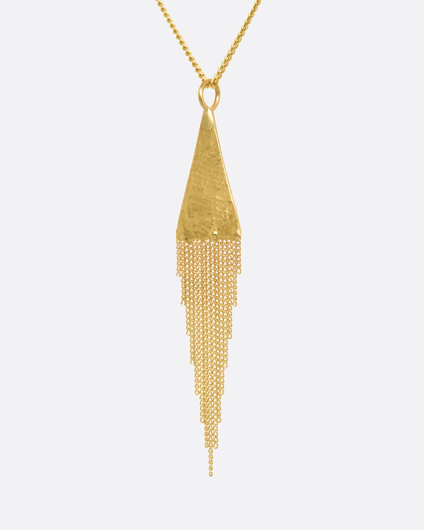 A yellow gold necklace with a fringed triangle pendant. View up close from the side.