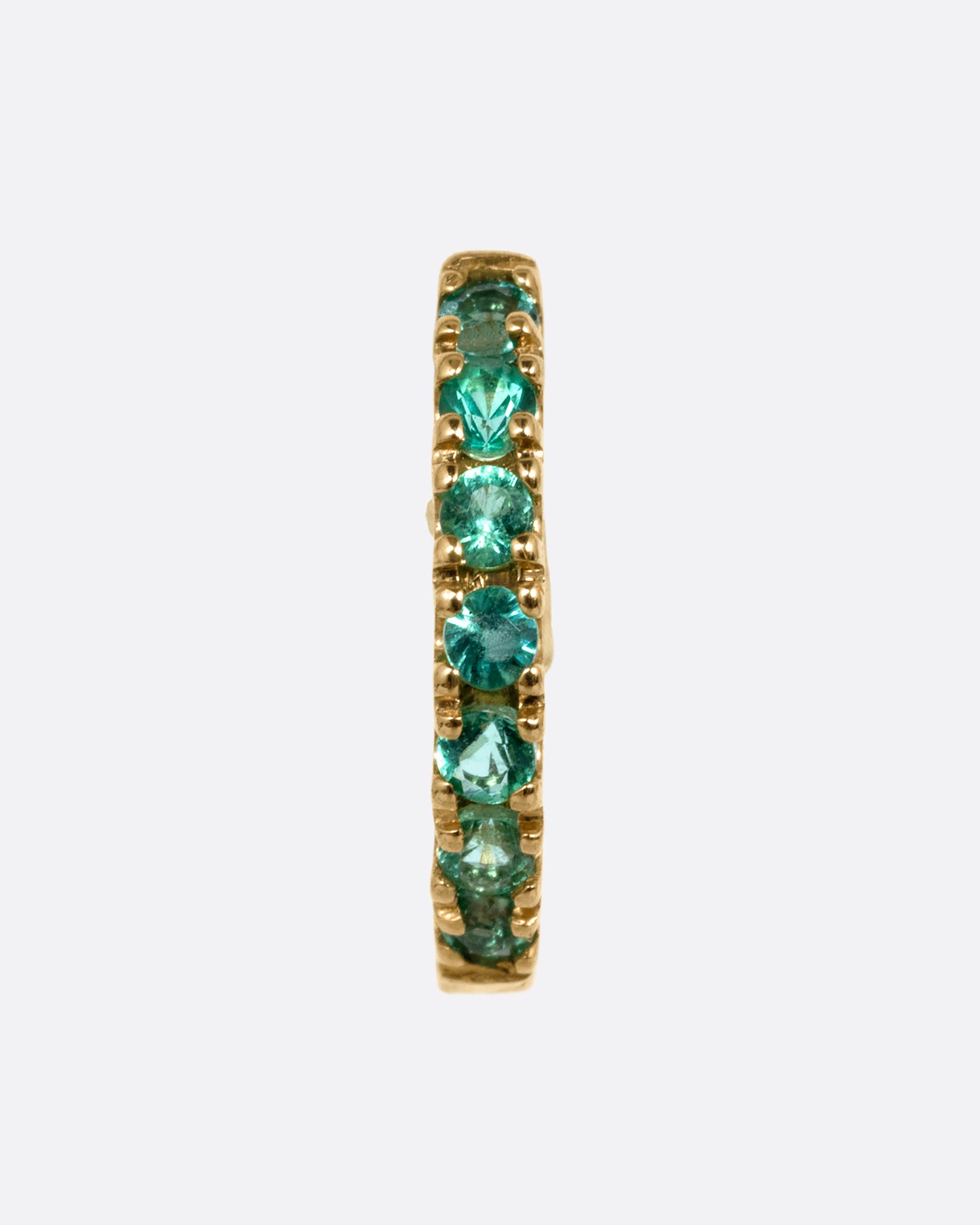 A yellow gold hinged hoop earring with pavé emeralds, shown from the front.