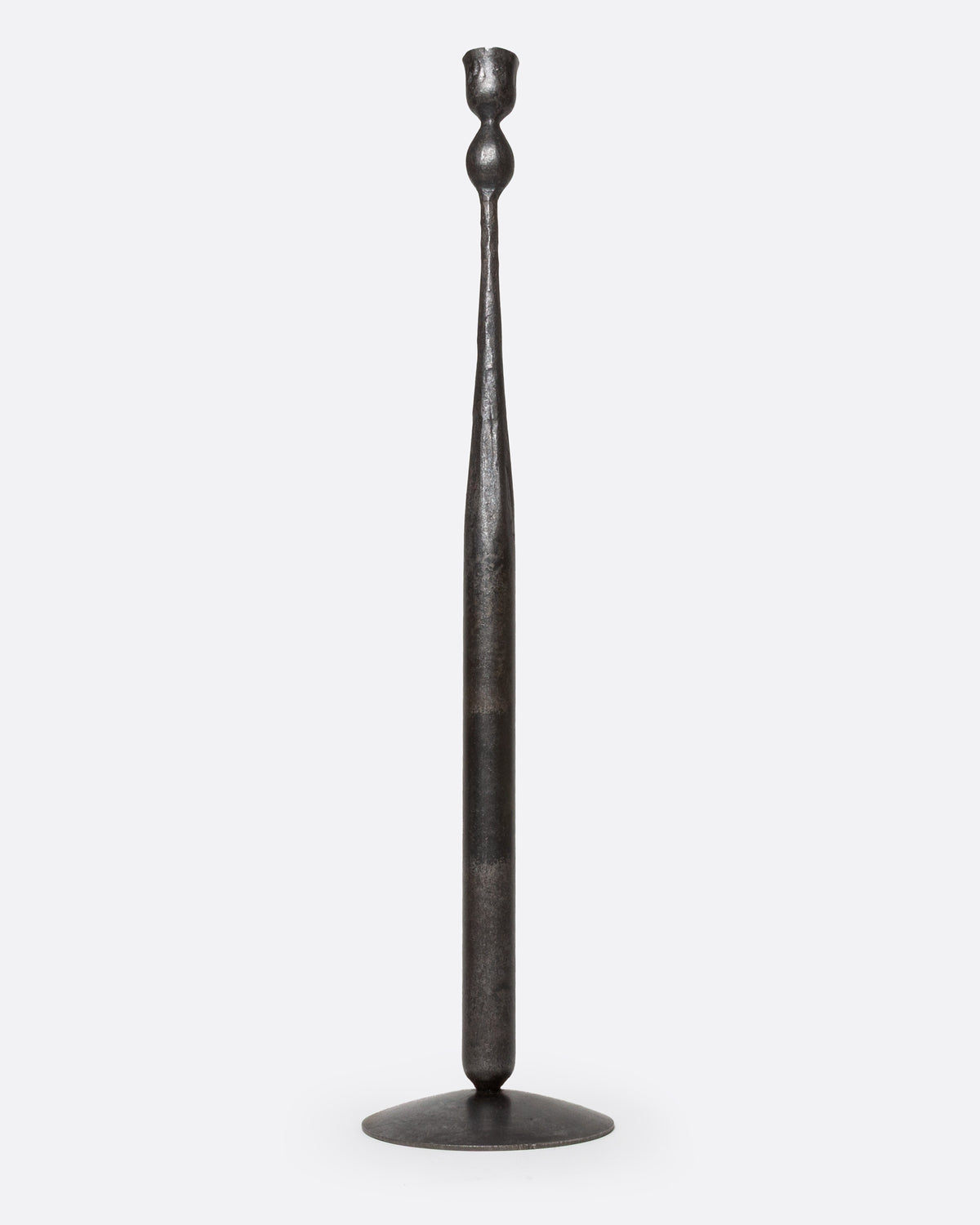 A tall, slender iron candlestick holder with a flared circular base, shown from the front.