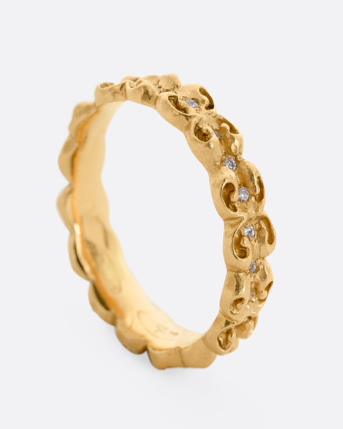A bubble floral infinity band with round white diamonds all the way around. Shown from the side, standing up.