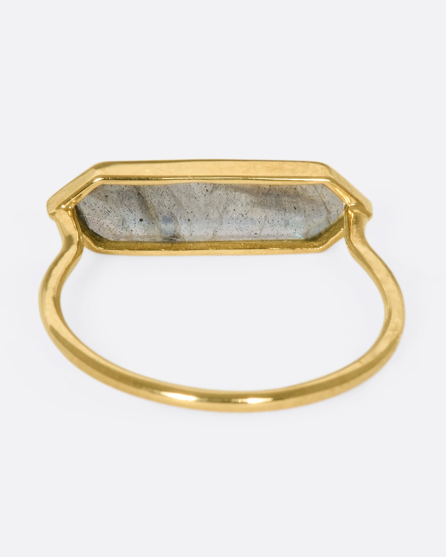 A yellow gold ring with a hexagonal labradorite bar, shown from the back.